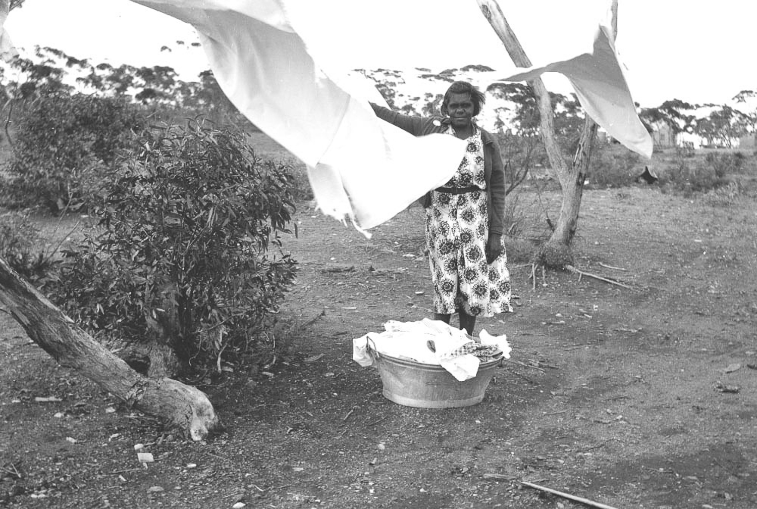 Marjorie Watson hanging out the mission washing in Cundeelee. Anangu women were often given households chores to do as part of mission life, as part of the assimilation process, and were often sent to farms to work as household labourers, for which they were never paid. 