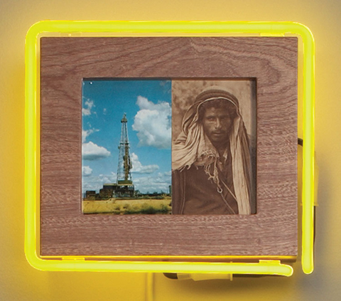 Photograph of man in turban and oil rig within yellow neon light 