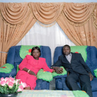 Sudanese couple holding hands in armchairs