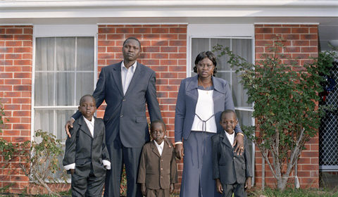 Sudanese family outside Australian home in formal wear