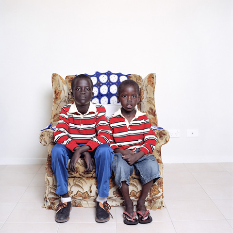 Sudanese brothers sharing armchair