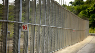 Colour photo of fence around Christmas Island Detention Centre