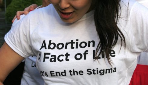 Woman wearing t-shirt with slogan: "Abortion: A Fact of Life. Let's End the Stigma"