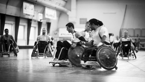 Black and white photo of a men's wheelchair rugby match