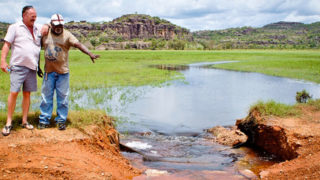 Aboriginal man showing another man a lake