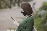woman in mask using phone